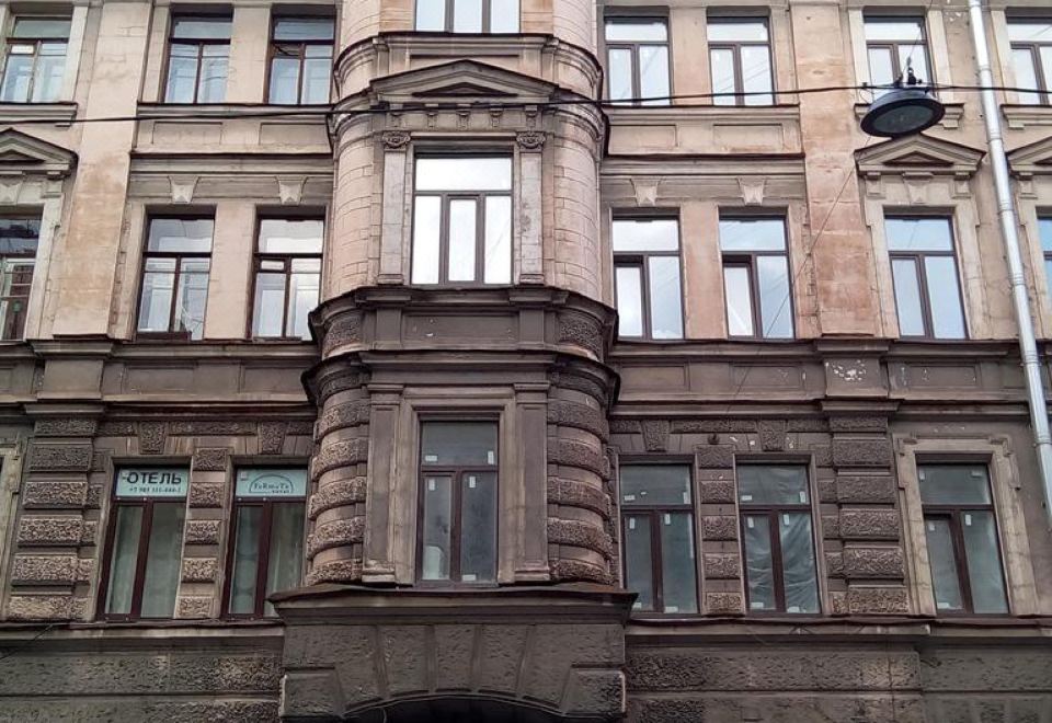 a large , old building with multiple windows and a red roof , located on a city street at Fabrika