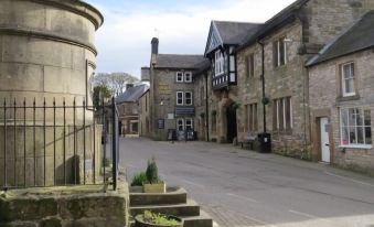 a street view of a stone building with a staircase and a round wall in the center at Bulls Head