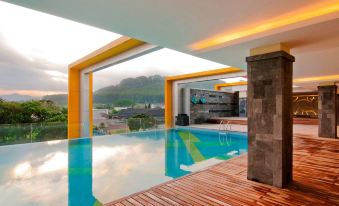a modern house with a large swimming pool and an orange structure on the roof at Grand Artos Hotel & Convention