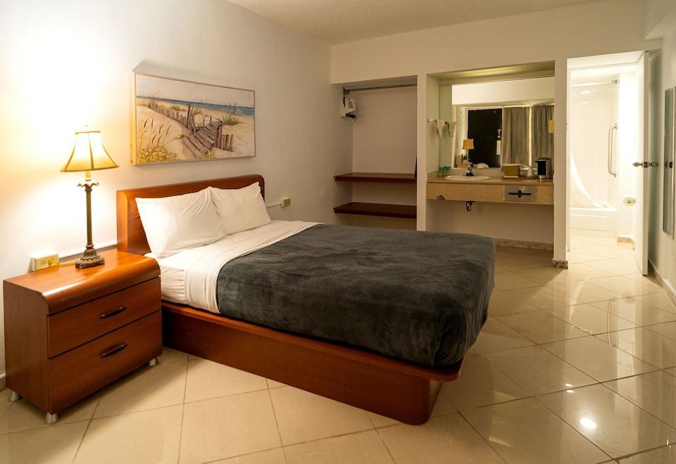 a large bed with a wooden headboard and footboard is in the middle of a room at Solace by the Sea
