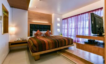 a large bed with a wooden headboard and footboard is in a room with a window at The Regenza by Tunga