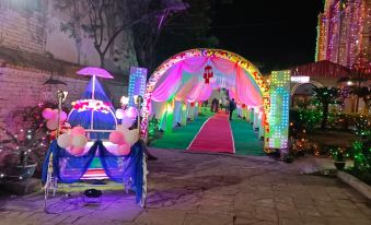 a colorful archway decorated with lights and flowers , leading to a pathway lit by colorful lights at Hotel Samrat
