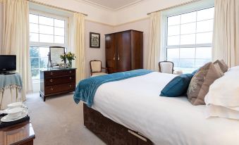 a large bedroom with a king - sized bed , a dresser , and a mirror on the wall at Ees Wyke Country House