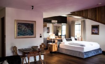 a large bedroom with a king - sized bed , a dining area , and a bathroom in the background at Romantik Hotel Turm