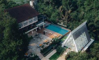 an aerial view of a house with a pool surrounded by trees and a golf course at Horison Green Forest Bandung