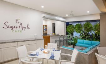 a modern kitchen and dining area with a white table , blue chairs , and a glass window at Beach View Hotel