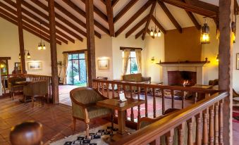 a spacious living room with wooden furniture , including a couch , chairs , and a dining table at Sweetwaters Serena Camp