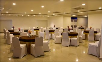 a large , empty banquet hall with multiple round tables and chairs set up for an event at Hotel Bella Vista