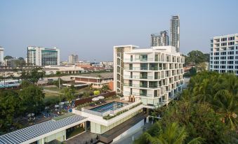 A large building with a central outdoor swimming pool and additional buildings on both sides at Mera Mare Pattaya