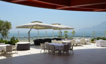 an outdoor dining area with several tables and chairs , as well as umbrellas providing shade at Grand Hotel Salerno