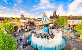 an amusement park with a water fountain in the center , surrounded by various rides and attractions at Hotel am Rhein