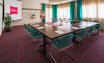 a conference room with a table , chairs , and papers is set up for a meeting at Ibis Firenze Nord Aeroporto