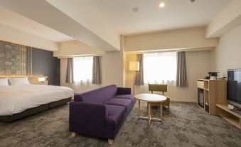 a modern hotel room with a purple couch , white bed , and grey carpet , along with other furniture and a bed at Hotel Kanazawa