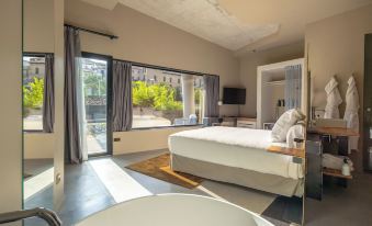 a modern bedroom with a large bed , a bathtub , and a view of the outdoors at Hotel Viura