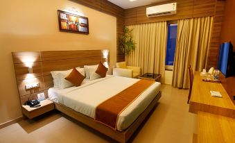 a large bed with a wooden headboard and white linens is in a hotel room at Imperial Heights
