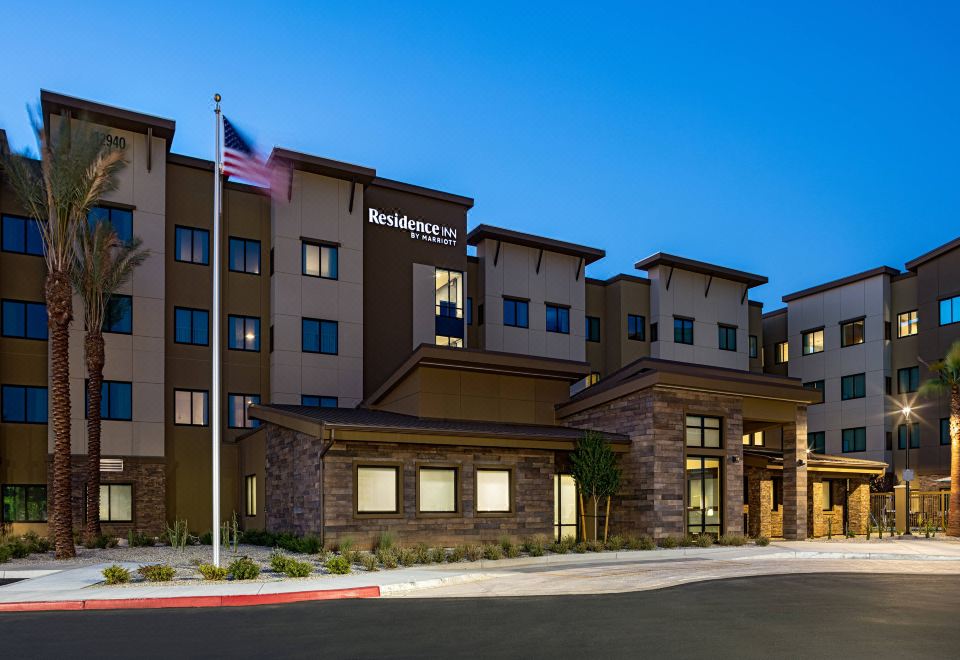 "a modern , multi - story hotel building with a flagpole and the name "" residence inn "" displayed above the entrance" at Residence Inn Riverside Moreno Valley