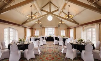 a large dining room with multiple tables and chairs set up for a formal event , possibly a wedding reception at St. Eugene Golf Resort & Casino