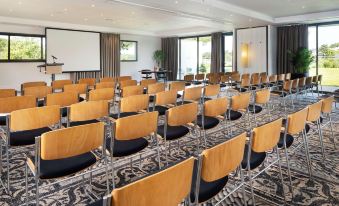 a conference room with rows of chairs arranged in a semicircle , ready for a meeting or presentation at Best Western Plus Hotel les Rives du Ter