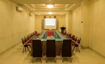 a large conference room with multiple rows of chairs arranged in a semicircle around a long table at Hotel Marina Bima