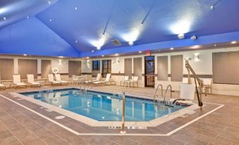 a large swimming pool with a white chair and blue ceiling in an indoor setting at Homewood Suites by Hilton Dover - Rockaway