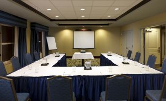 a conference room set up for a meeting , with chairs arranged in a semicircle around a long table at Homewood Suites by Hilton Dover - Rockaway