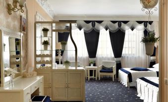 a luxurious hotel room with a blue and white theme , featuring a large bed , a desk , and a television at Green House