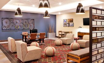 a hotel lobby with various seating options , including couches , chairs , and a dining table at Four Points by Sheraton Saginaw
