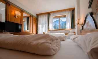a hotel room with three beds , two of which are twin beds and one is a double bed at Hotel Dolomiti Schloss