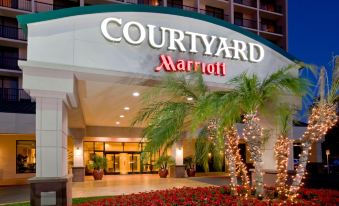 the entrance to a courtyard marriott hotel with palm trees and christmas decorations , surrounded by holiday lights at Courtyard by Marriott Los Angeles Pasadena/Monrovia