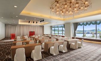 a conference room with multiple chairs arranged in rows and a chandelier hanging from the ceiling at Loisir Hotel Naha