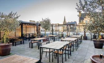 a rooftop dining area with several tables and chairs , creating an inviting outdoor space for patrons at Mercure Newport