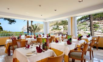 a large dining room with multiple tables and chairs arranged for a group of people to enjoy a meal at Grupotel Molins