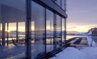 a modern building with large windows and a beautiful view of the ocean , as well as snow - covered ground and trees at Son Spa, an Ascend Member