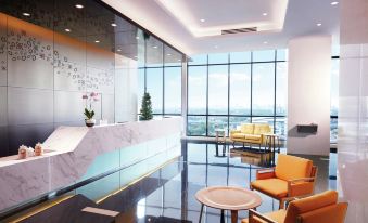 a modern office lobby with a reception desk , chairs , and a large window overlooking the city at Hilton Garden Inn Puchong