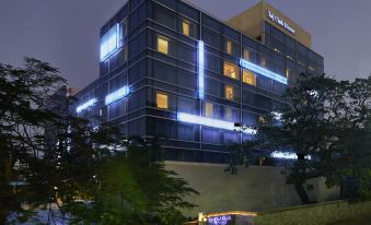 "a modern building with blue lights and the name "" julius ' hotel "" is lit up at night" at Taj Club House