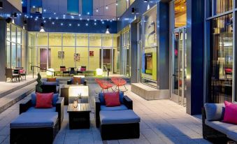 an outdoor seating area at a bar , with several couches and chairs arranged around it at Aloft Chesapeake