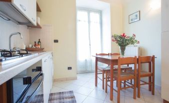 a small kitchen with a dining table and chairs , as well as a stove and oven at Hotel La Cretonne