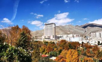 The city has a skyline in front and mountains behind it, featuring an oriental style at Espinas Palace Hotel Tehran