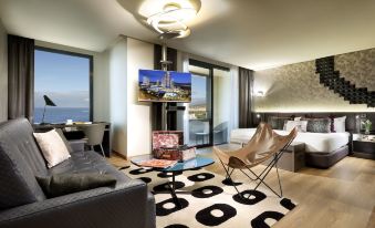 a modern living room with a large flat - screen tv mounted on the wall , a couch , and a dining table at Hard Rock Hotel Tenerife