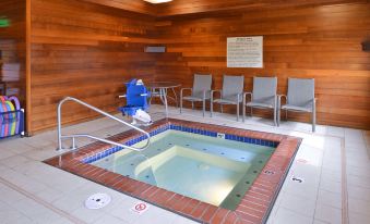 an indoor hot tub surrounded by chairs and benches , providing a relaxing atmosphere for people to relax and enjoy the atmosphere at Hampton Inn Portland East