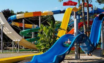 a colorful water park with various slides and play structures for children to enjoy , including a blue slide at Hotel Arboretum