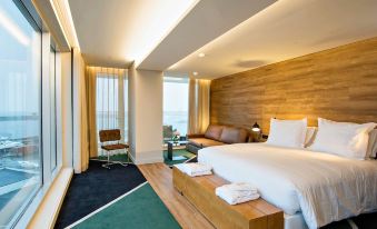 a hotel room with a large bed , wooden headboard , and a view of the ocean at Octant Ponta Delgada