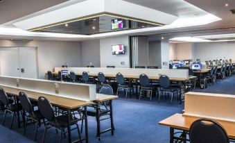 a large conference room with multiple rows of chairs and tables , as well as a tv mounted on the wall at Tryp Cayo Coco