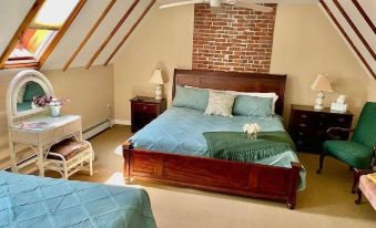 a large bed with a wooden headboard is situated in a room with brick walls and ceiling fan at Black Swan Inn