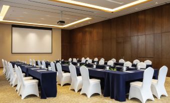 a conference room set up for a meeting , with chairs arranged in rows and a projector on the wall at Pullman Changbaishan Resort
