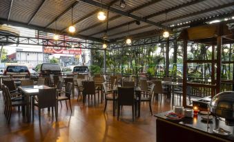 a large , open room with tables and chairs is filled with people sitting at tables at Solaris Hotel Malang