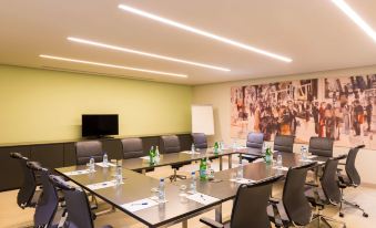 a conference room with a long table , chairs , and water bottles set up for a meeting at Radisson Hotel, Dakar Diamniadio
