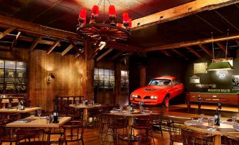 a restaurant with wooden tables and chairs , a chandelier , and a red car parked outside at Sheraton Skyline Hotel London Heathrow