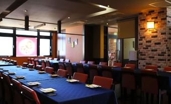 a large dining room with multiple tables and chairs arranged for a group of people to enjoy a meal together at Hotel Wing International Chitose
