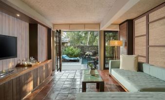 a spacious living room with a couch , coffee table , and sliding glass door leading to an outdoor patio at Jeeva Klui Resort